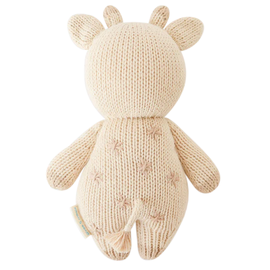 A cream-colored Cuddle + Kind Baby Giraffe with pointed ears and subtle textural stitching, viewed from the back against a white background.