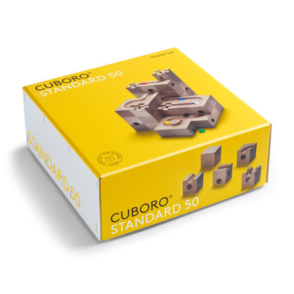 A yellow Cuboro 50 Marble Run Starter Set featuring illustrations of wooden block constructions on top, labeled with the product name and logo.