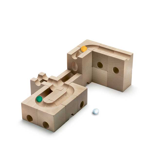 Wooden puzzle blocks with intricately carved paths and holes, featuring a Cuboro Speed Marble Run Extra Set - Speed resting inside a recess and a green ball positioned in a groove, designed to enhance fine motor skills, on a white background.