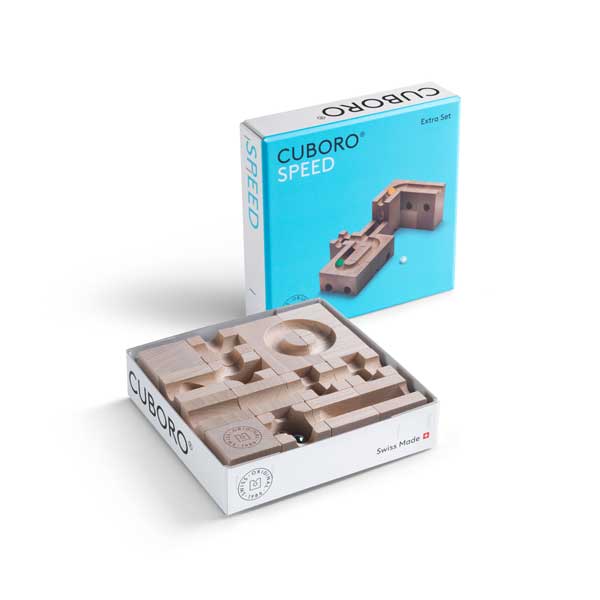 Cuboro Speed Marble Run Extra Set - Speed with its packaging. The set includes various wooden blocks and tracks for constructing marble runs, displayed next to its blue box marked "Swiss Made". This CUBORO