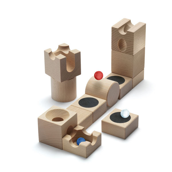 A wooden Cuboro Jump Marble Run Extra Set consisting of blocks with various shapes and holes, each containing a small, colorful ball (red, blue, and white). The blocks are arranged on a white background.