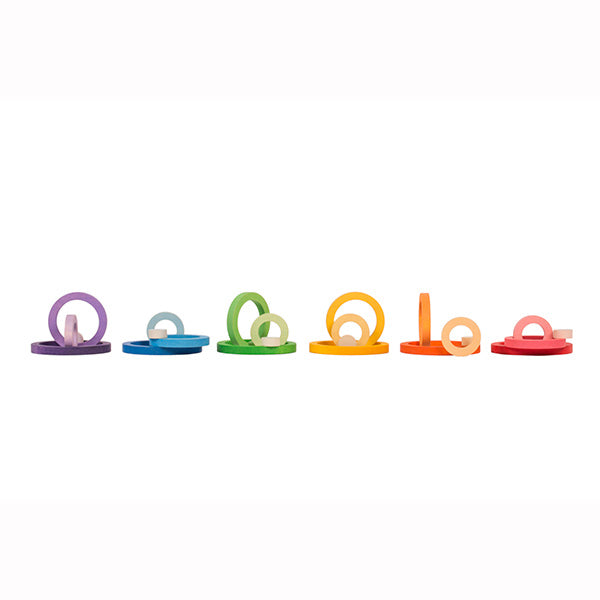 A row of colorful, transparent Grapat Nesting Rings in Grapat's rainbow palette isolated on a white background.