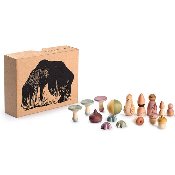 A collection of Grapat Moonlight Tale wooden spinning tops made with non-toxic dyes, showcasing various shapes and sizes displayed in front of their packaging, which features black illustrations of trees on a tan background.