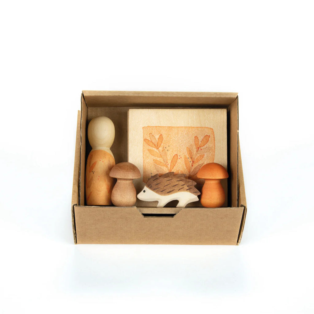 The Hello Autumn Set (Grapat X Ostheimer Limited Edition) includes two wooden peg dolls, two mushrooms, a hedgehog figure, and a leaf-print block in a small box—ideal for collectors of unique Autumn sets.