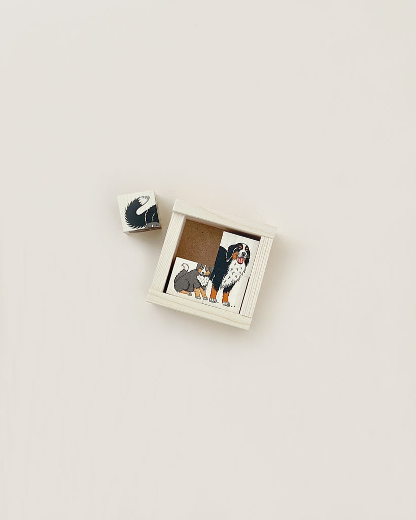 A small Wooden Block Puzzle - 4 Piece Farm Animals box with a partial puzzle depicting two dogs, placed on a light beige background.