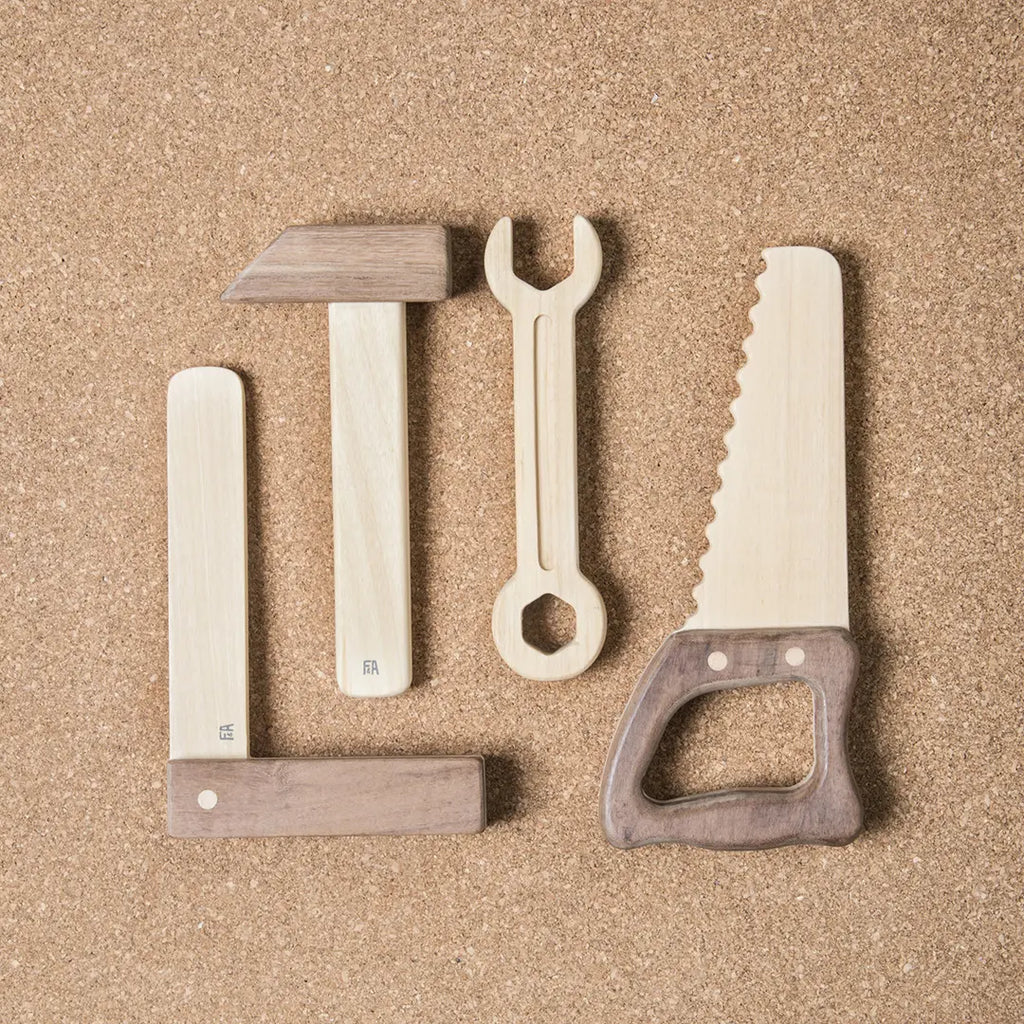 Sentence with Product Name: Heirloom quality Wooden Tool Set including a hammer, screwdriver, wrench, and saw arranged on a sandy background.