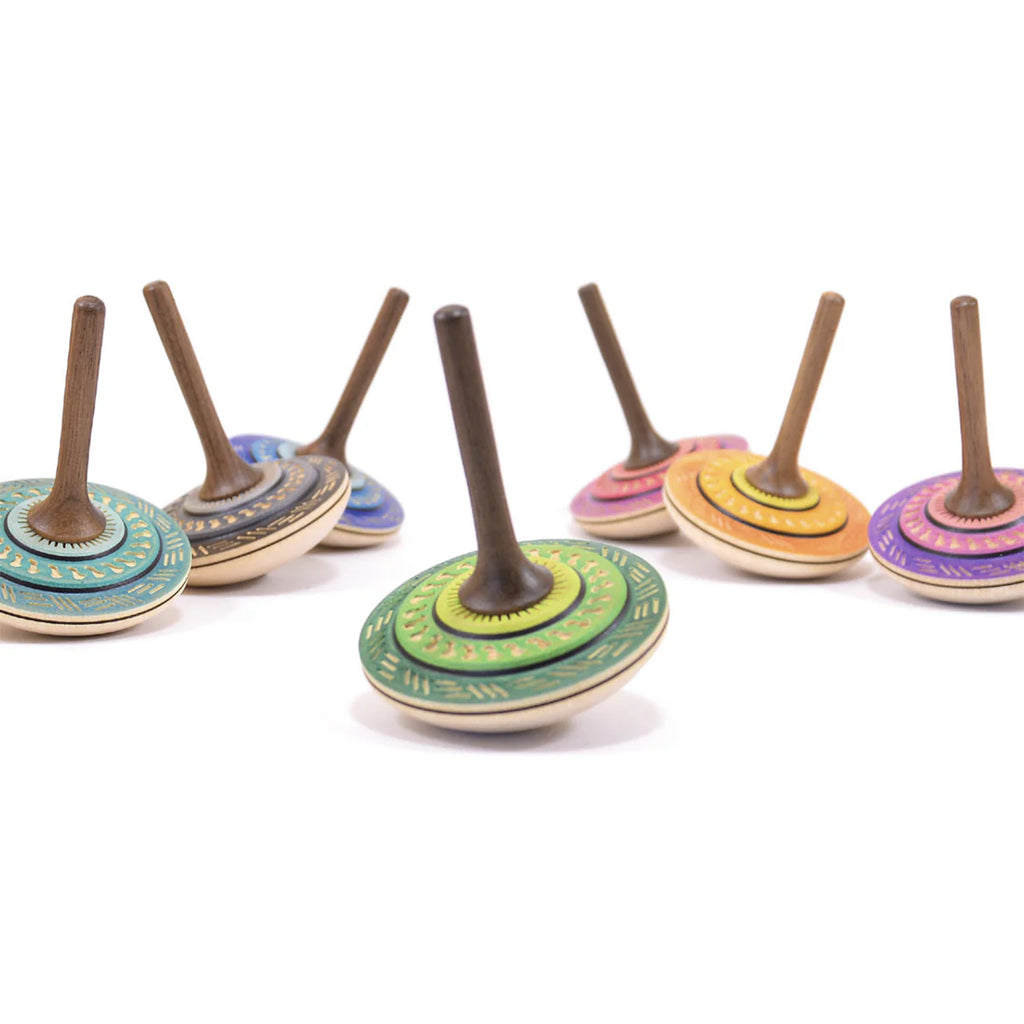 The Mader Bonbon Spinning Top in purple, crafted from Austrian wood and featuring embossed patterns, stands upright on a white background.