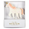 A glittering Meri Meri Unicorn Glitter Candle with pink and orange mane details, packaged in a white box labeled "meri meri birthday candle." The unicorn features a gold horn and colorful speckles.
