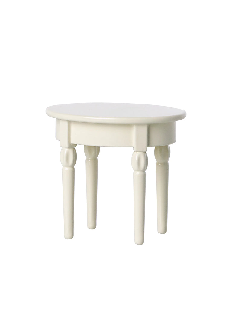A simple white round table from the Maileg Farmhouse - Fully Furnished set with four straight, cylindrical legs on a plain white background.