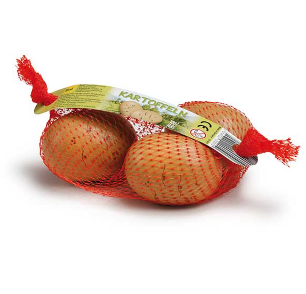 Three Potatoes in a Net Pretend Food wrapped in red netting with a label, handcrafted in Germany, isolated on a white background.