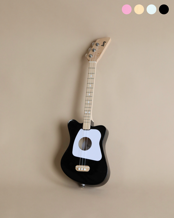 A wooden kid's guitar painted in black and white.