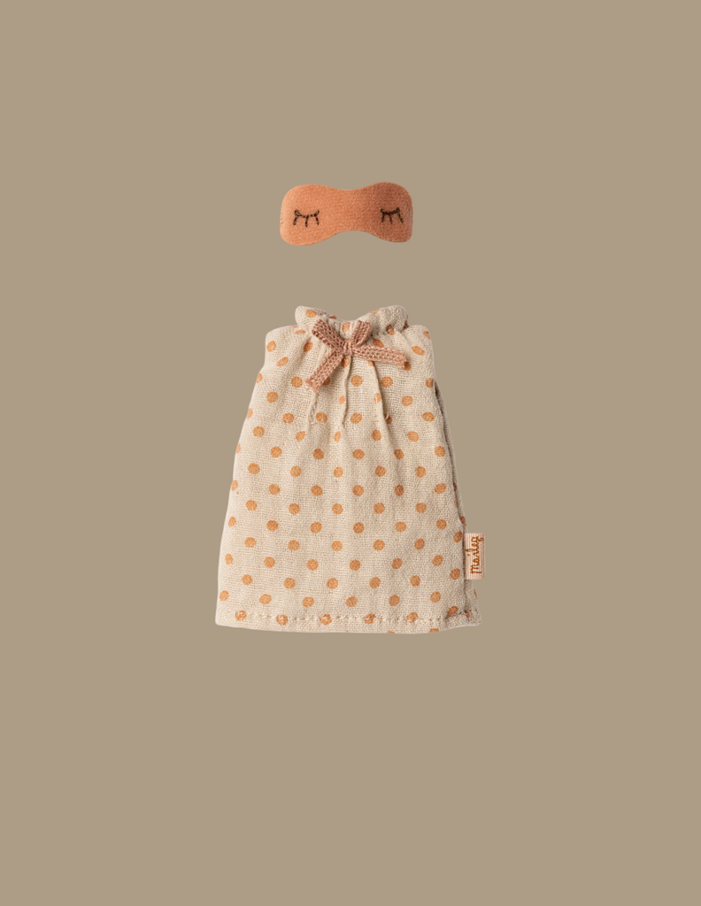 A small beige Maileg Extra Clothing: Nightgown For Mom Mouse, with orange polka dots and a bow at the neck, plus a matching orange nightgown-style eye mask with embroidered closed eyes, displayed on a plain beige background.