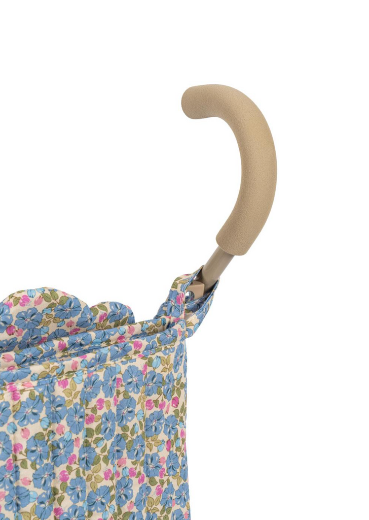 Close-up of the Konges Sloejd Doll Stroller - Rose Flower, showing its beige foam handle and double wheels. The stroller features a floral fabric with blue, green, and pink flowers on a white background against a plain white backdrop.