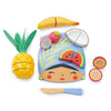 A colorful wooden playset featuring a character's face depicted on a Tropical Fruit Chopping Board surrounded by tropical fruit pieces such as pineapple, watermelon, banana, and passion fruit, with a knife and spatula