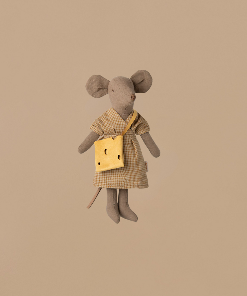 The Maileg Mum Mouse - Light Brown wears a checkered dress and carries a yellow cheese-shaped bag. Made of soft cotton, this charming toy rests against a plain beige background, adding warmth to any mouse furniture setup. (Ships in one week).
