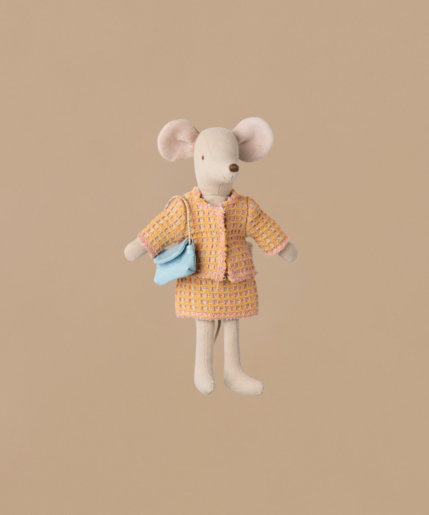 The Maileg Suit For Mum Mouse features a plush mouse toy with a chic orange tweed jacket and skirt, accessorized by a light blue lady bag over its shoulder, all set against a plain beige background.