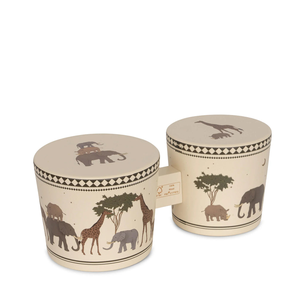 Two Konges Sløjd Wooden Bongo Drums - Safari made from FSC-certified beech wood with beige backgrounds and illustrations of African wildlife, including giraffes, elephants, and trees, on a white surface.
