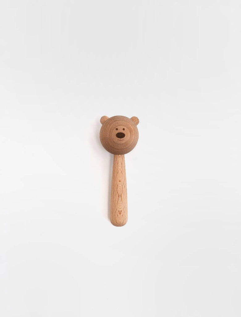 The Sabo Concept Bear Rattle - Natural, featuring a handle and a round bear face with carved ears, eyes, and nose, is displayed on a plain white background.
