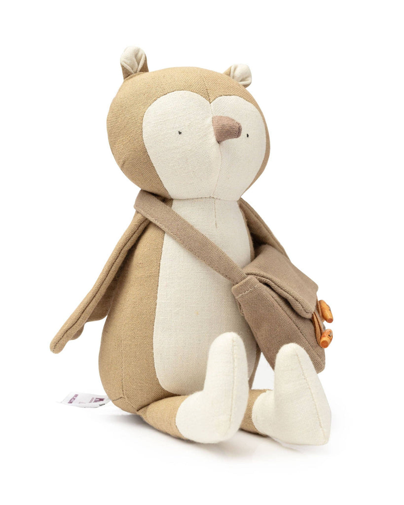 Owen The Owl is a plush toy with a light brown body, white face and belly, and small round ears. It has minimalist sewn facial details and wears a beige satchel over its shoulder.