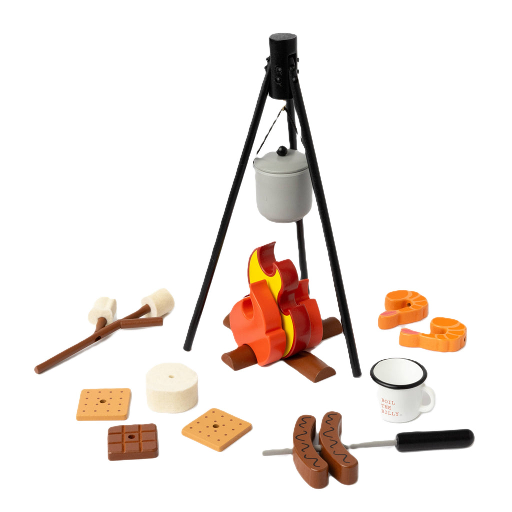 The Wooden Camp Fire Set includes a tripod and pot, plastic flames, sausages, marshmallows on sticks, graham crackers, chocolate, a mug, knife, and cookie cutters—perfect for kids' indoor camping pretend play.