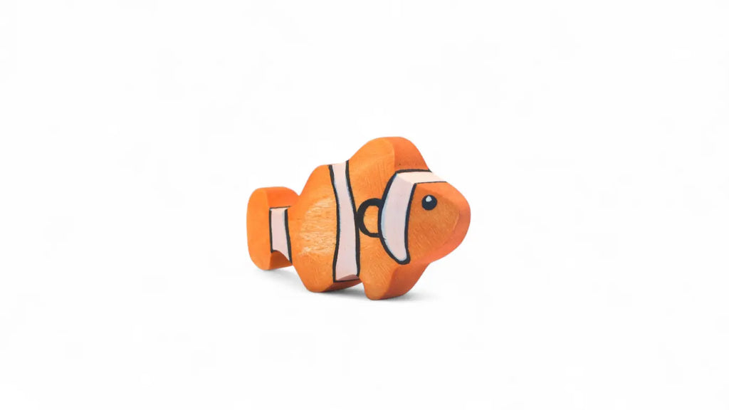 The Handmade Holzwald Clownfish is a small, orange wooden toy with white and black stripes, placed on a plain white background—a delightful addition to any collection of handmade wooden toys.