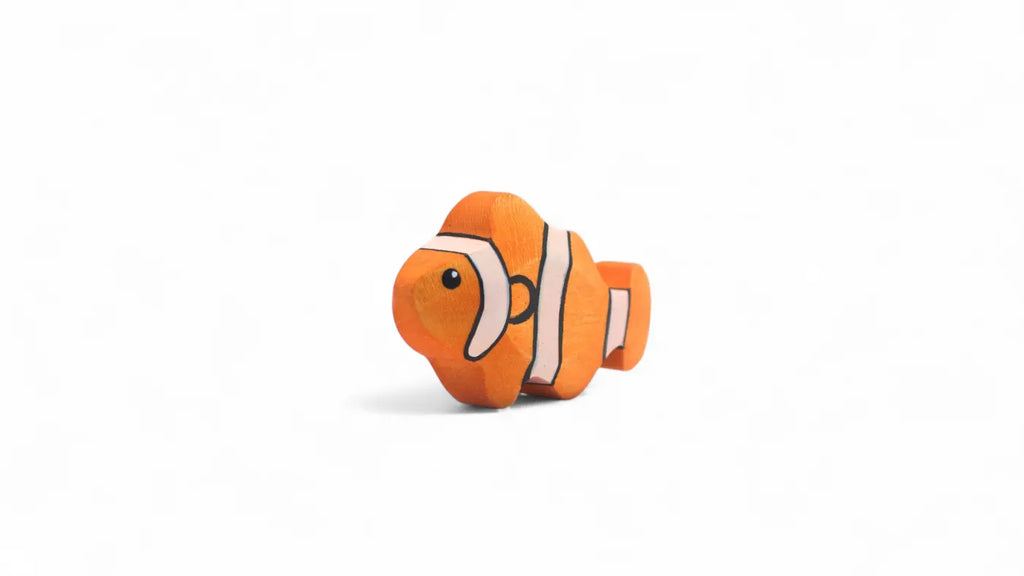 The Handmade Holzwald Clownfish, a small orange and white wooden toy with black stripes, is displayed on a white background, highlighting the charm of Holzwald toys.