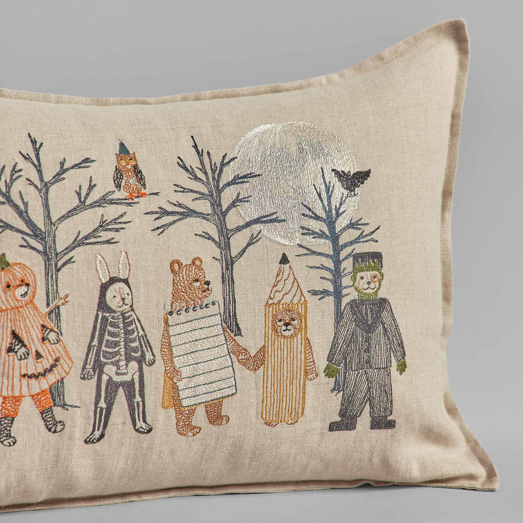 Decorative Halloween Full Moon Masquerade pillow featuring embroidered designs of five children in animal-themed costumes, such as a rabbit and bear, with trees and birds under a silver moon on beige fabric.