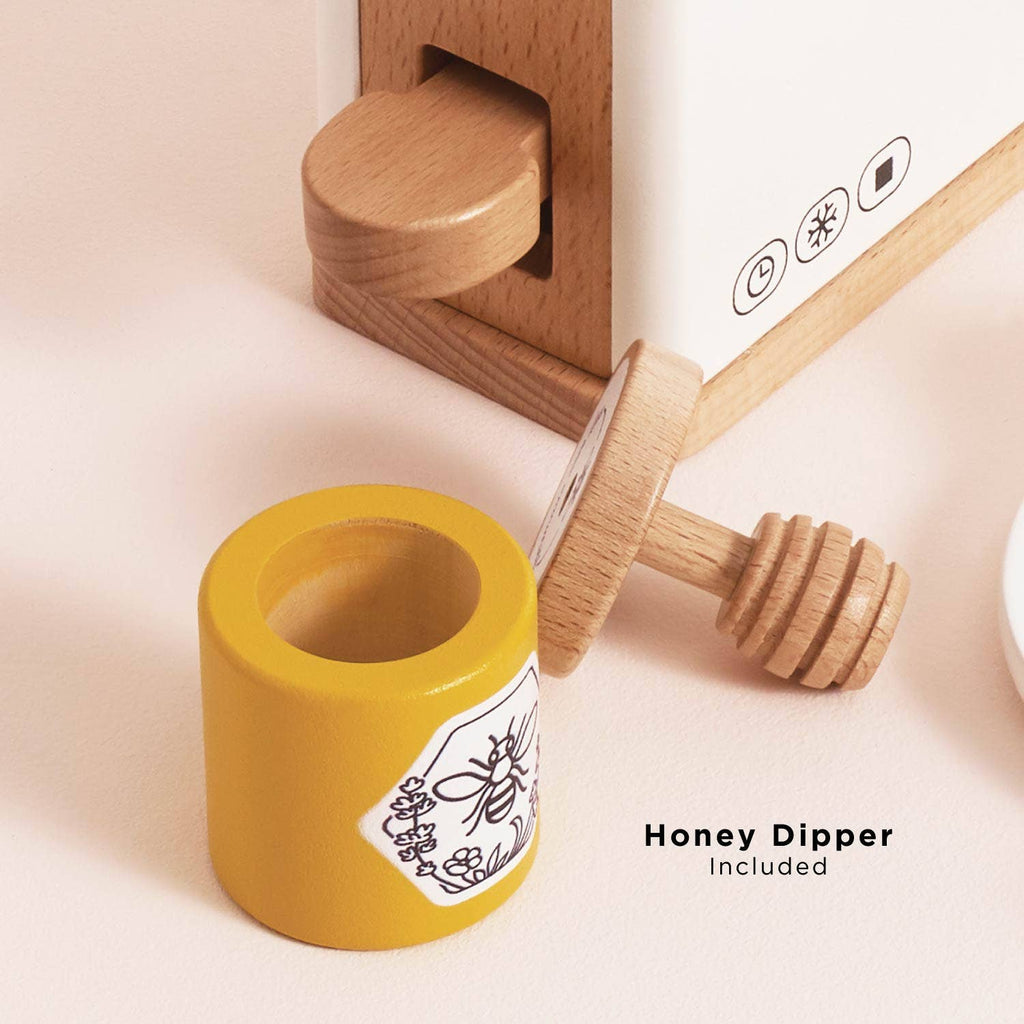 Close-up of FSC-certified wood honey dipper beside yellow holder with bee illustration, next to wooden and white container. Text: "Honey Dipper Included." Product: Pop-up Toaster & Breakfast Set (ships in one week).
