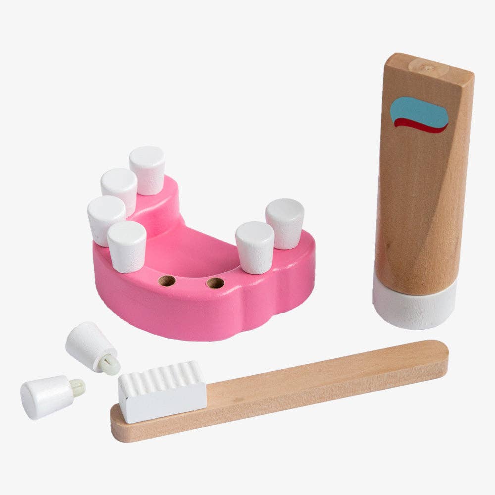 The Wooden Dentist Set includes a pink jaw, removable white teeth, wooden toothbrush, and toothpaste tube—perfect for imaginative dental role play and adventures.