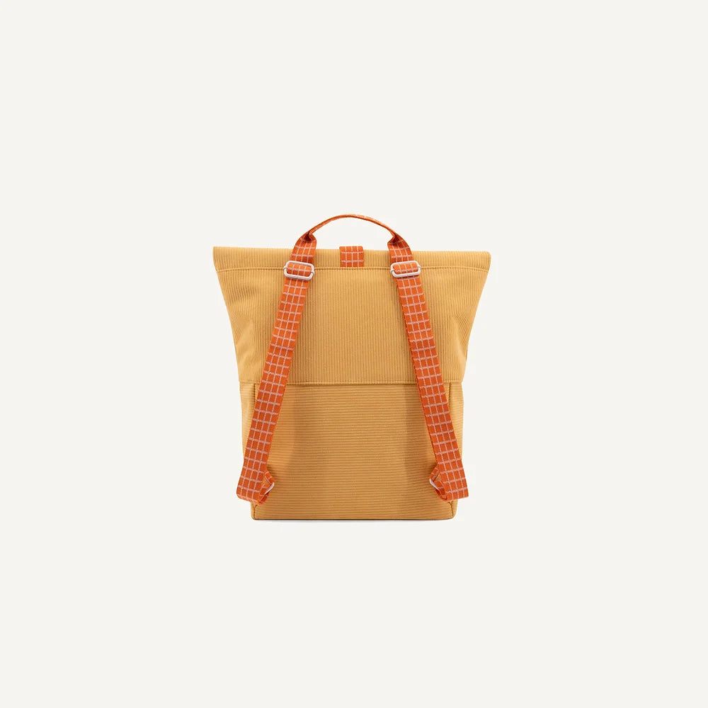 A yellow Sticky Lemon corduroy backpack with contrasting red and orange checkered straps, viewed against a plain white background.