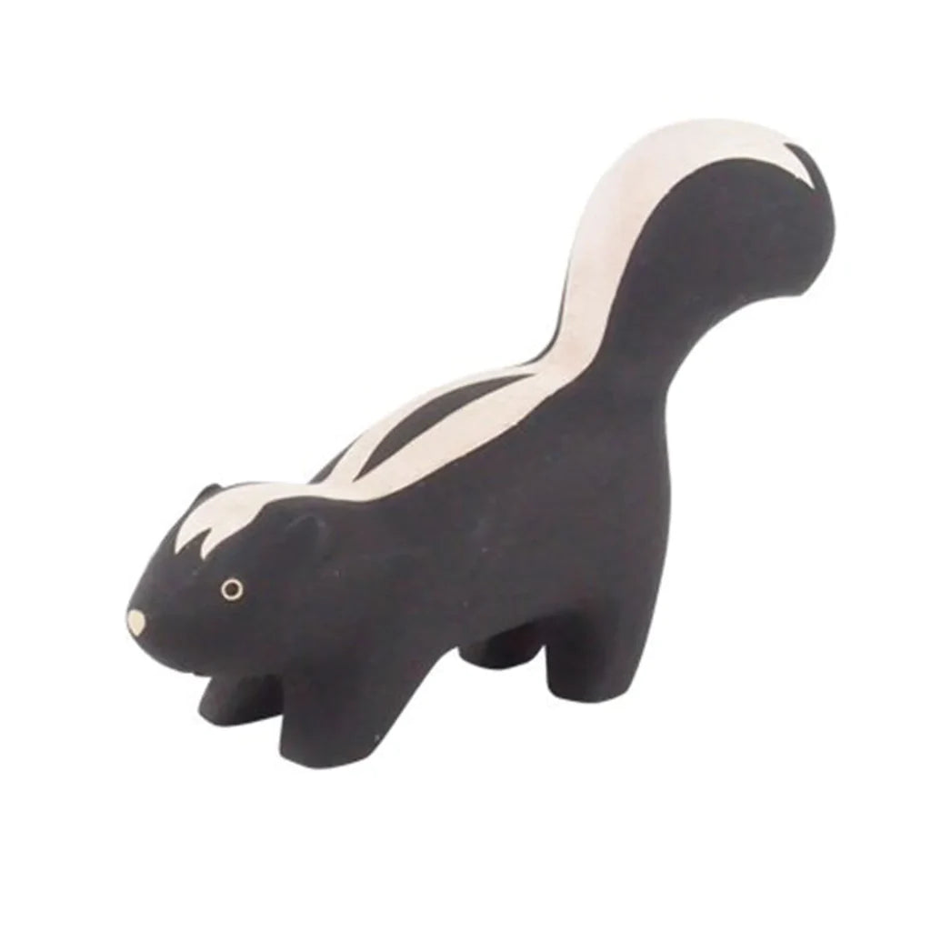 A Handmade Tiny Wooden Forest Animals - Skunk figurine, painted mostly in black with white stripes and featuring small, carved details for eyes and nose. The sculpture is simplistic, with a smooth, stylized form.