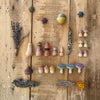 A collection of Grapat Moonlight Tale, painted with non-toxic dyes, neatly arranged with small star-shaped items and botanical accents, on a rustic wooden background.