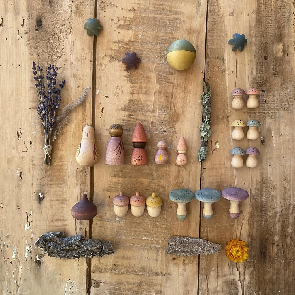 A collection of Grapat Moonlight Tale, painted with non-toxic dyes, neatly arranged with small star-shaped items and botanical accents, on a rustic wooden background.