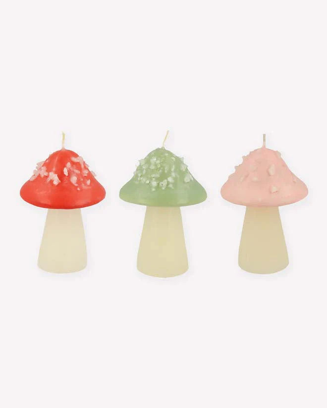 Three Meri Meri Mushroom Candles in red, green, and pink, each with a different texture on their caps, against a plain white background.