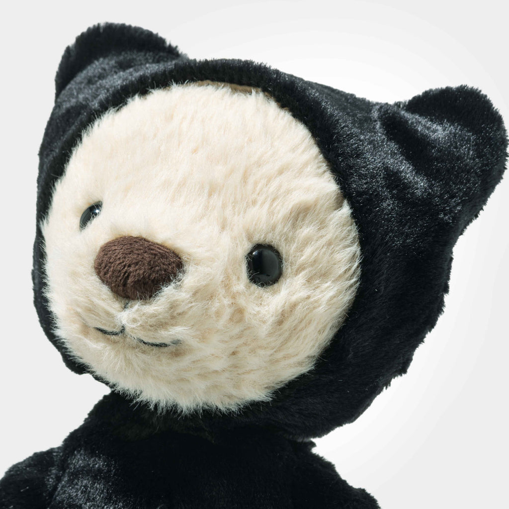 The Steiff Mr. Bones Teddy Bear features a cream-colored face and a black skeleton costume with bear ears, posed slightly to the side against a plain white background—an ideal addition to any plush collection.