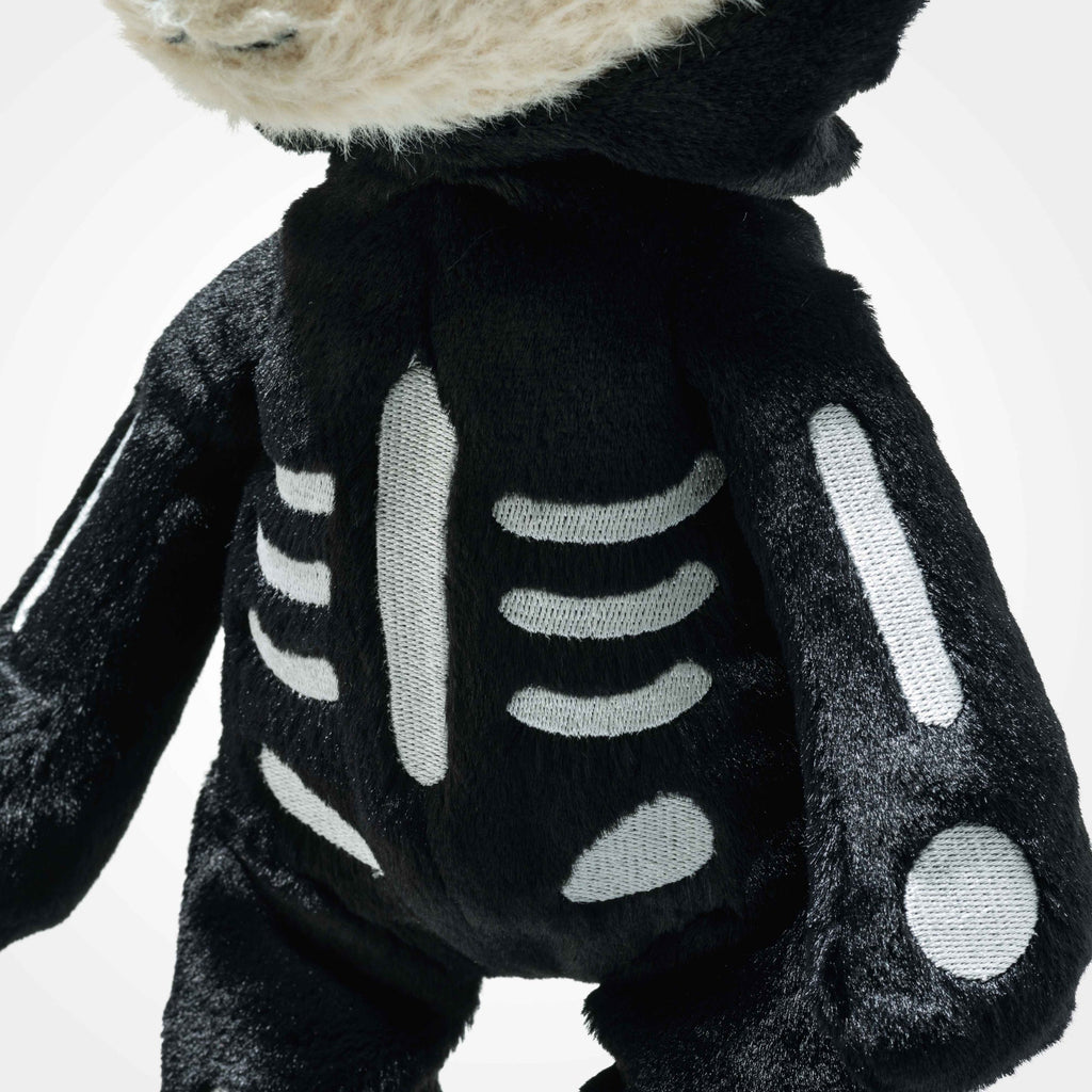 A close-up of the Steiff Mr. Bones Teddy Bear in a skeleton costume plush with white bone details on its chest and arms, and the head partially visible at the top.