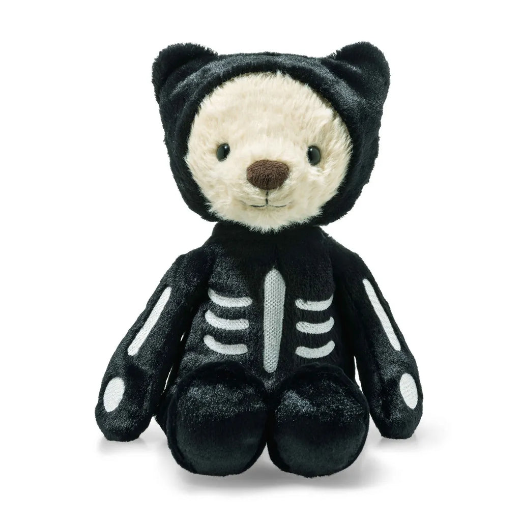 The Steiff Mr. Bones Teddy Bear, dressed in a black skeleton costume with cat-like ears, sits upright on a white background—a charming addition to any plush collection.