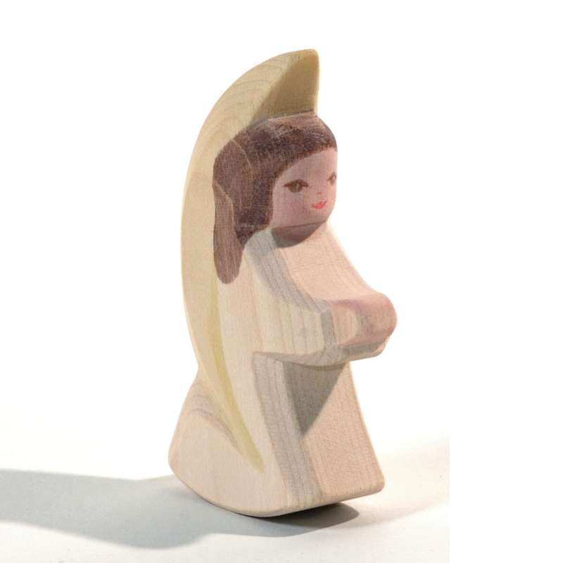 A handcrafted wooden figurine of a young girl with brown hair, wearing a beige dress and a light yellow scarf, arms crossed, on a white background. 
Ostheimer Little Angel - Off-White