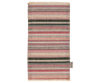 A traditional multicolored striped woven rug with a fringed edge, displayed vertically against a black background. A small label from the Maileg Farmhouse - Fully Furnished collection is visible on the bottom right corner.