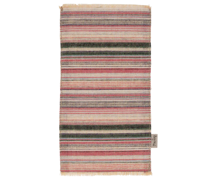 A traditional multicolored striped woven rug with a fringed edge, displayed vertically against a black background. A small label from the Maileg Farmhouse - Fully Furnished collection is visible on the bottom right corner.