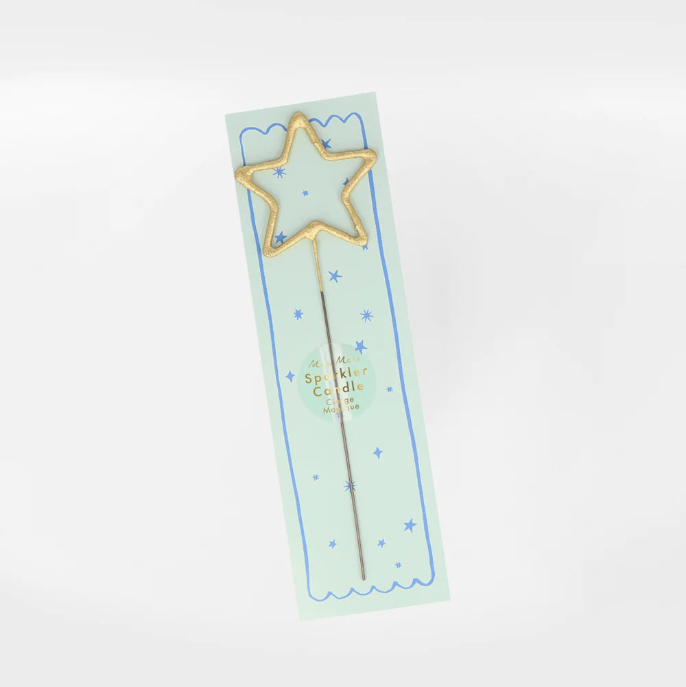 A Meri Meri Gold Sparkler Star Candle in blue packaging with gold glitter and light blue accents, displaying text and decorative stars.