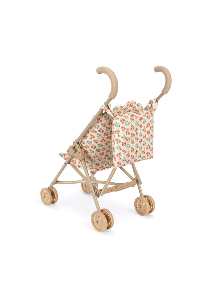 The Konges Sloejd Doll Stroller - Lumina features light wooden handles, double wheels, a floral-patterned fabric seat, and a matching carriage bag. Designed for children, it’s shown on a white background.