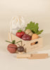 Sliceable wooden vegetable toys in a wooden crate with a wooden knife.