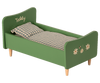 A green wooden Wooden Bed for Teddy Dad - Dusty Green toddler bed with wooden legs, featuring a plaid blanket and 'teddy' written on the headboard, adorned with white daisy decals.
