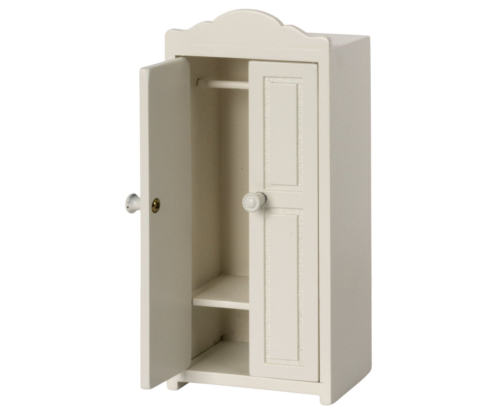 A small, white, wooden Maileg Small Closet with one door opened showing two shelves and a hanging rod inside. The closet features a scalloped top, simple knob handles on both doors, and golden hangers for an elegant touch. Made from FSC wood, this piece is both stylish and sustainable.