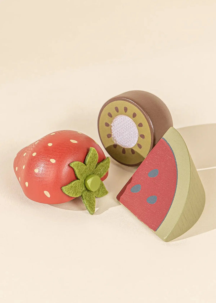 Wooden red strawberry with green felted stem, half wooden kiwi and half a slice of red watermelon.