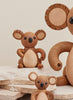 Three Spring Copenhagen Matilda koala bear figurines of different sizes, crafted with visible wood grains and smooth finish, positioned on a stone surface against a light beige background.