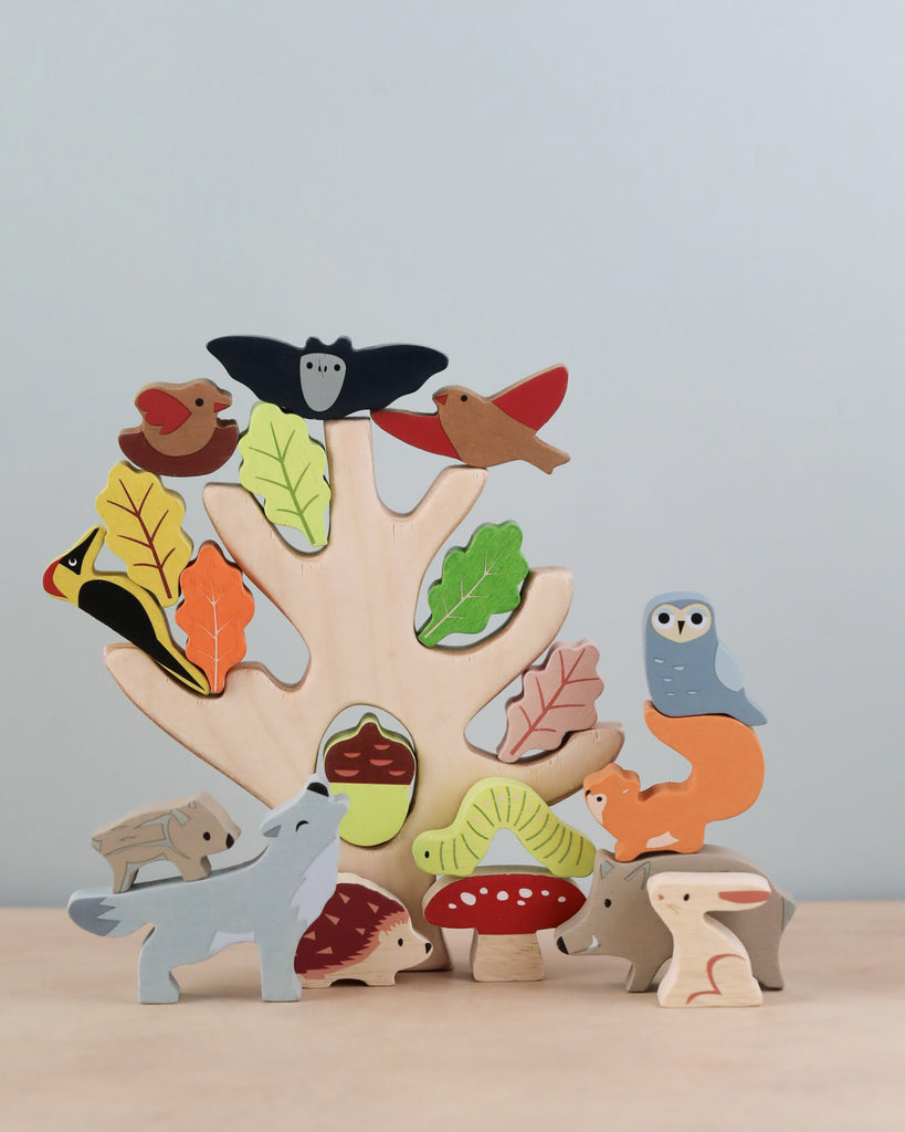A colorful wooden Stacking Forest puzzle with animal shapes like birds, an owl, and a fox, each nestled into corresponding slots, set against a soft beige background.
