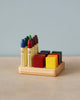 A set of colorful Crayon Tray for Stockmar - 8 x 8 Slots neatly arranged in a linden wood holder on a light blue background.