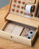 Wooden Cash Register made from sustainably sourced wood, featuring buttons and a paper roll at the top, and a pull-out drawer containing wooden coins and notes at the bottom.